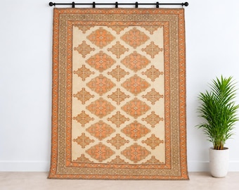 May include: A rectangular area rug featuring a cream-colored center with a repeating pattern of orange diamond-shaped motifs. The rug is framed by a wide orange border with intricate geometric designs and a thin outer brown trim.