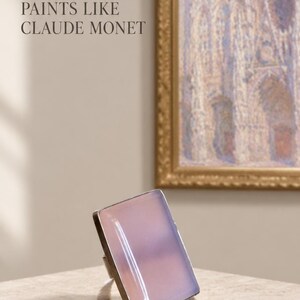 Pu&ograve; includere: Un anello rettangolare con una pietra liscia, traslucida e rosa pallido incastonata in una montatura in metallo argentato. Il testo "WHEN NATURE PAINTS LIKE CLAUDE MONET" &egrave; visibile nell'angolo in alto a sinistra, sopra un quadro incorniciato.