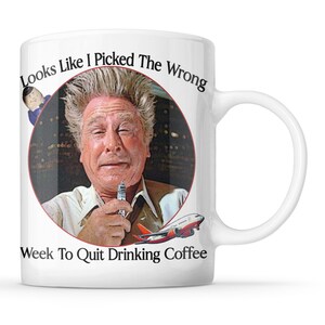 May include: White ceramic mug with a humorous design. The mug features a portrait of a man holding a small object, with the text "Looks Like I Picked The Wrong Week To Quit Drinking Coffee" and an image of an airplane.