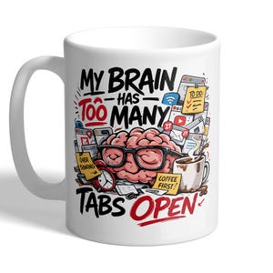 May include: White ceramic mug with a humorous design. The mug features a cartoon brain wearing glasses, surrounded by digital icons, a clock, and a coffee cup. Text reads "MY BRAIN HAS TOO MANY TABS OPEN."