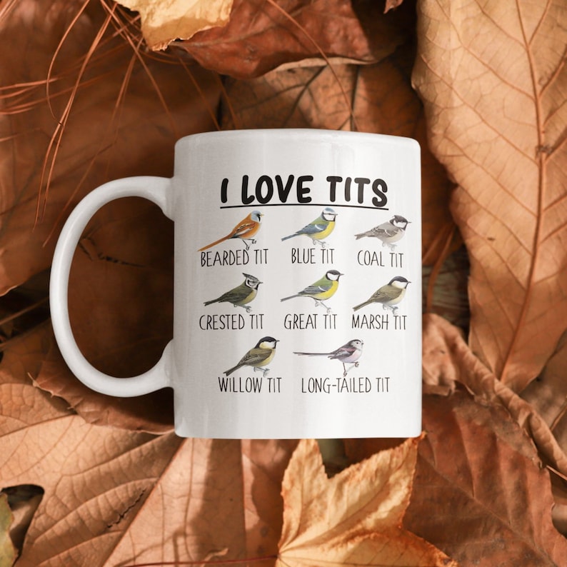 May include: White ceramic mug with a black and white image of different types of birds. The text "I LOVE TITS" is printed in black at the top of the mug. Below the text are the names of the birds: Bearded Tit, Blue Tit, Coal Tit, Crested Tit, Great Tit, Marsh Tit, Willow Tit, and Long-tailed Tit.
