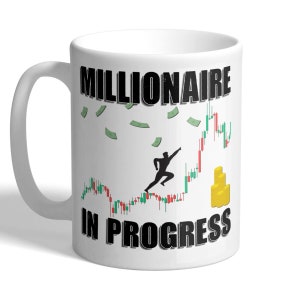 May include: White ceramic coffee mug featuring a black graphic of a person running up a stock chart with money falling from the sky. The text "Millionaire in Progress" is printed on the mug.