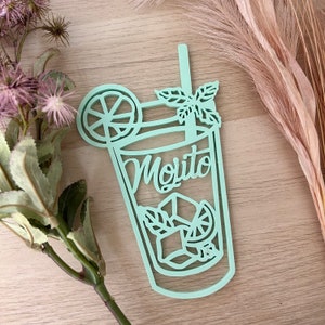 Peut inclure: Une découpe en vert clair d'un verre à cocktail mojito avec un quartier de citron vert, des feuilles de menthe et le mot "Mojito" écrit à l'intérieur du verre.