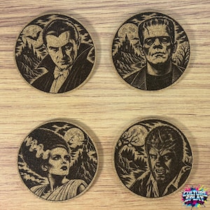 May include: A set of four circular cork coasters featuring laser-engraved portraits of classic horror characters including Dracula, Frankenstein's monster, the Bride of Frankenstein, and a werewolf, each set against a dark, detailed moonlit landscape.