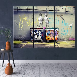 May include: A graffiti-covered wall with the words "Life is short, still the one" painted in yellow. Two figures stand in front of the wall, with their backs to the viewer, and two large, colorful trash cans are in front of them.