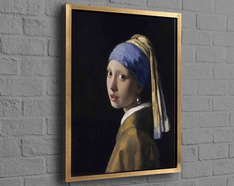 Puede incluir: Impresión enmarcada de la famosa pintura "La joven de la perla" de Johannes Vermeer. La obra de arte presenta a una joven con un pañuelo azul y amarillo, un pendiente de perla y una chaqueta dorada. La pintura está sobre un fondo oscuro.