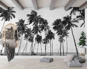 May include: Black and white mural featuring a tropical beach scene with tall palm trees. A hanging wicker chair with a gray blanket and patterned pillow is in the foreground. Gray floor cushions and a potted plant complete the scene.