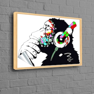 May include: A black and white illustration of a monkey wearing headphones with colorful paint splatters on its face. The monkey is holding its chin and looking to the side. The headphones are red, green, blue, and yellow.