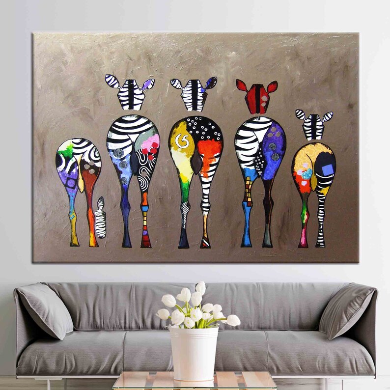 May include: A colorful abstract painting of six zebras standing in a row, facing away from the viewer. The zebras are painted in a variety of bright colors, including red, yellow, blue, green, and purple. The background is a muted brown.