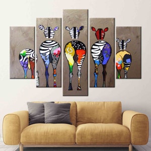 May include: A multi-panel canvas painting featuring five colorful zebras with black and white stripes. The zebras are painted in a whimsical style with bright colors and patterns. The background is a light brown color.
