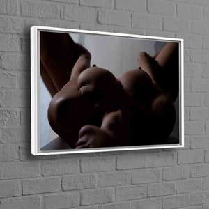 May include: A black and white photo of a person lying on their back with their arms and legs spread out. The person's body is in focus, while the background is blurred.
