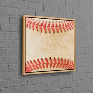 May include: A framed canvas print of a vintage baseball with red stitching. The baseball is worn and has a faded, cream-colored background.