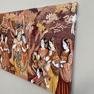 Pode incluir: Uma pe&ccedil;a de arte de parede de madeira colorida que representa uma cena da mitologia hindu. A obra de arte apresenta um grupo de pessoas, incluindo Krishna e Radha, cercados por &aacute;rvores e flores. A obra de arte &eacute; feita de madeira e &eacute; pintada em cores vibrantes.