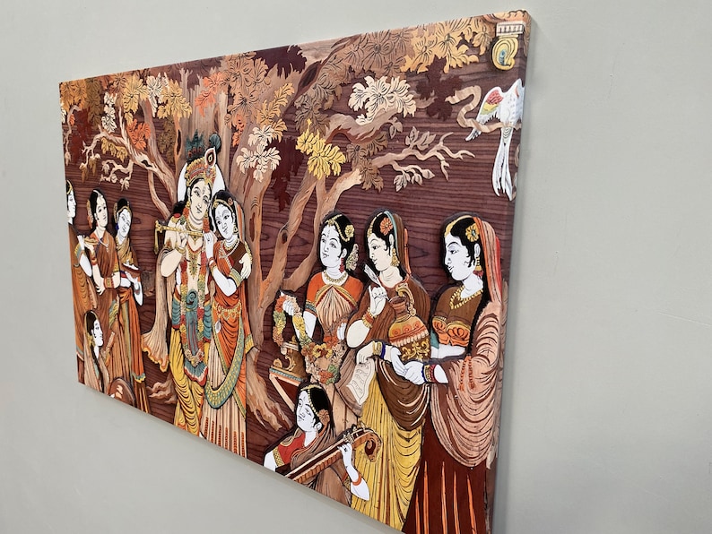 Pode incluir: Uma pe&ccedil;a de arte de parede de madeira colorida que representa uma cena da mitologia hindu. A obra de arte apresenta um grupo de pessoas, incluindo Krishna e Radha, cercados por &aacute;rvores e flores. A obra de arte &eacute; feita de madeira e &eacute; pintada em cores vibrantes.