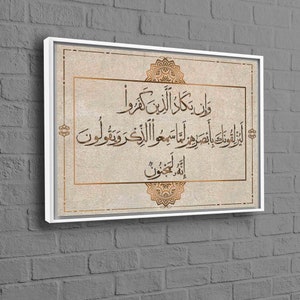 May include: A beige canvas print with a white frame features an Islamic calligraphy quote in gold lettering. The quote is surrounded by decorative gold floral designs.