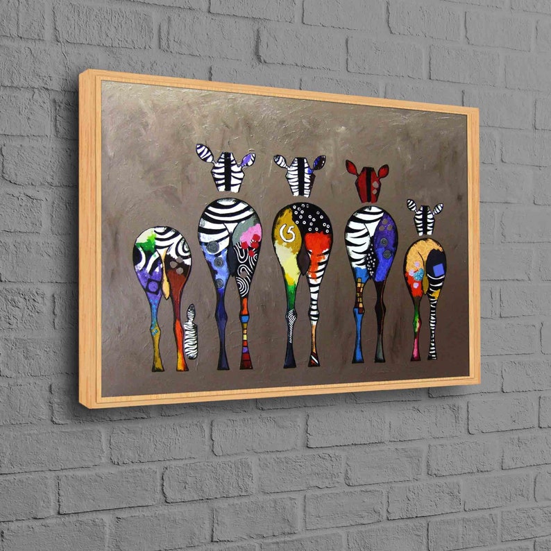 May include: A framed painting of six colorful zebras standing in a row, facing away from the viewer. The zebras are painted in a stylized, abstract style with bold colors and patterns. The background is a muted gray.