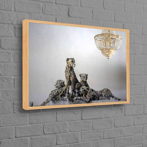 May include: A framed painting of four cheetahs, painted in a realistic style, with a gold chain around their necks. The cheetahs are standing on a white background, with a chandelier hanging above them.