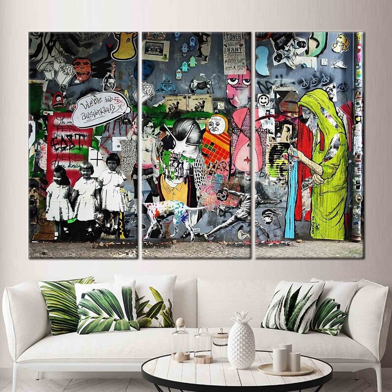 May include: A three-panel canvas print featuring a colorful and chaotic street art scene. The artwork is a collage of various images, including a dog, people, and text. The text includes the words "We've had to be disruptive" and "The East is here".