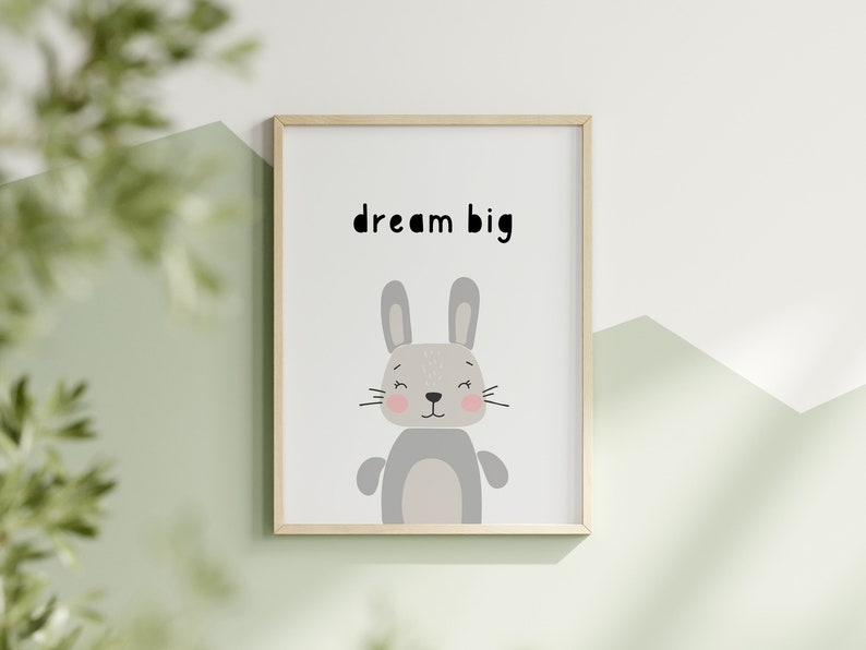 K&ouml;nnte beinhalten: Gerahmter Druck mit einem Cartoon-Hasen und dem Text "dream big". Der Hase ist grau mit rosa Wangen und einem hellgrauen K&ouml;rper. Der Rahmen ist aus hellem Holz, der Hintergrund ist wei&szlig; und gr&uuml;n.