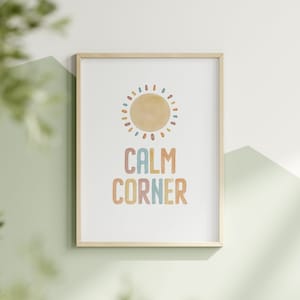 Może przedstawiać: Wydruk w ramie z akwarelowym słońcem i tekstem "CALM CORNER" w kolorach tęczy.