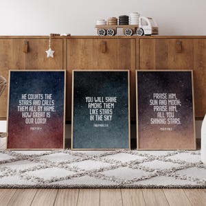 May include: Three framed prints with a galaxy background and inspirational quotes about stars. The quotes are "He counts the stars and calls them all by name. How great is our Lord!" "You will shine among them like stars in the sky." and "Praise Him, sun and moon; praise Him, all you shining stars."