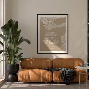 May include: A framed print with a beige background and white abstract lines. The text reads "The curious paradox is that when I accept myself just as I am, then I can change."