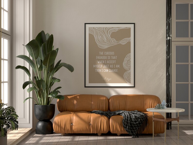May include: A framed print with a beige background and white abstract lines. The text reads "The curious paradox is that when I accept myself just as I am, then I can change."