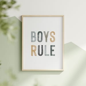 May include: A framed print with the text "BOYS RULE" in colorful, brushstroke-style lettering. The letters are in shades of blue, green, and yellow.