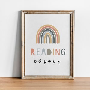 May include: A framed print featuring a rainbow design in shades of pink, orange, yellow, blue, and grey. The text "READING corner" is written below the rainbow.
