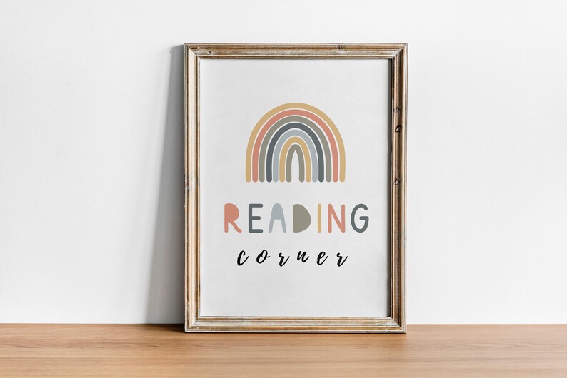May include: A framed print featuring a rainbow design in shades of pink, orange, yellow, blue, and grey. The text "READING corner" is written below the rainbow.