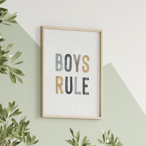 May include: A framed print with the text "BOYS RULE" in colorful, stylized lettering. The print is on a white background and has a light wood frame.
