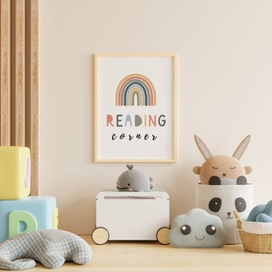 May include: A white toy chest with wheels, a rainbow print with the text "READING corner" in a wooden frame, a grey whale plush toy, a brown bunny plush toy, a grey cloud plush toy, a white and black panda storage basket, and a wicker basket with a blue plush toy.