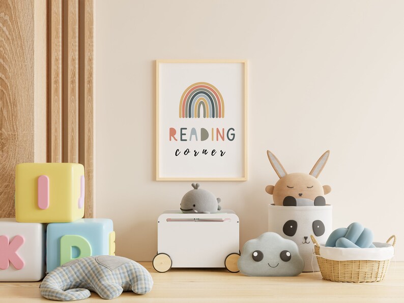 May include: A white toy chest with wheels, a rainbow print with the text "READING corner" in a wooden frame, a grey whale plush toy, a brown bunny plush toy, a grey cloud plush toy, a white and black panda storage basket, and a wicker basket with a blue plush toy.