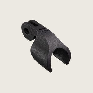 May include: A black, curved bracket with a textured surface. The bracket has a circular hole and a slot on the top. A stylized "R" is visible on the top of the bracket. The bracket has a curved, open-ended design.