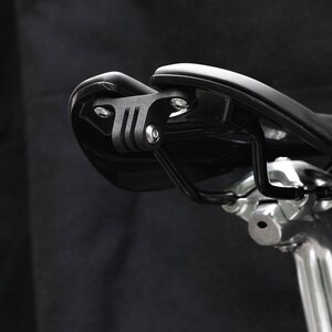 Peut inclure: Une selle de vélo noire avec un support GoPro noir fixé à l'arrière.