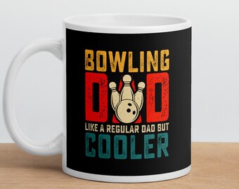 Pode incluir: Caneca de cerâmica branca com um design preto. O design apresenta o texto "Bowling Dad" com um gráfico de bola de boliche e pinos. O texto "Like a regular dad but cooler" também está incluído no design.