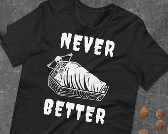 Puede incluir: Camiseta negra con un esqueleto blanco en un ataúd y el texto "NEVER BETTER".