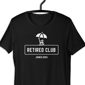 Può includere: Maglietta nera con una grafica bianca di una sedia da spiaggia sotto un ombrello e il testo "Retired Club Joined. 2025"