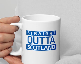 Może przedstawiać: Biały kubek ceramiczny z niebieskim nadrukiem "STRAIGHT OUTTA SCOTLAND".