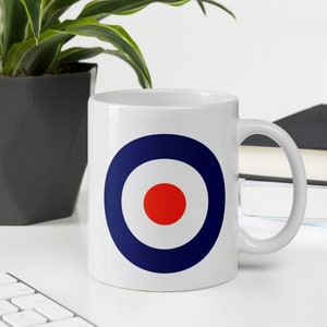 May include: White ceramic mug with a blue and red target design. The target has a white center and a red circle in the middle.