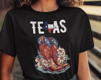 Puede incluir: Camiseta negra con la palabra "TEXAS" en letras blancas desgastadas y un gráfico de botas de vaquero con un diseño de bandera de Texas y margaritas blancas.