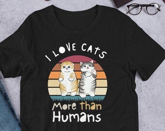 May include: Black t-shirt with a vintage-style graphic of two cats and the text "I love cats more than humans".