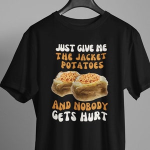 May include: Black t-shirt with a white graphic that says "Just give me the jacket potatoes and nobody gets hurt". The graphic also features two baked potatoes with beans on top.