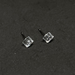 Könnte beinhalten: Ein Paar silberne Ohrstecker mit klaren quadratischen Kristallen.
