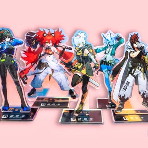 May include: Five acrylic anime character figures with vibrant colors. Each figure stands on a rectangular base with text. The characters have unique outfits and hairstyles, including red, green, and white hair. The background is a soft pink.