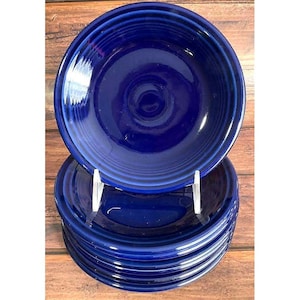 May include: A stack of six round, deep blue ceramic bowls with a glossy finish. Each bowl features a series of concentric circular ridges along the outer rim, creating a textured, stepped design that is consistent across the entire set of dishes.