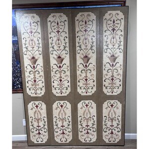 May include: A four-panel folding screen featuring a light beige background with dark brown borders. Each panel displays a vertical arrangement of painted floral motifs, scrolling vines, and a central basket design in shades of red, green, and tan.