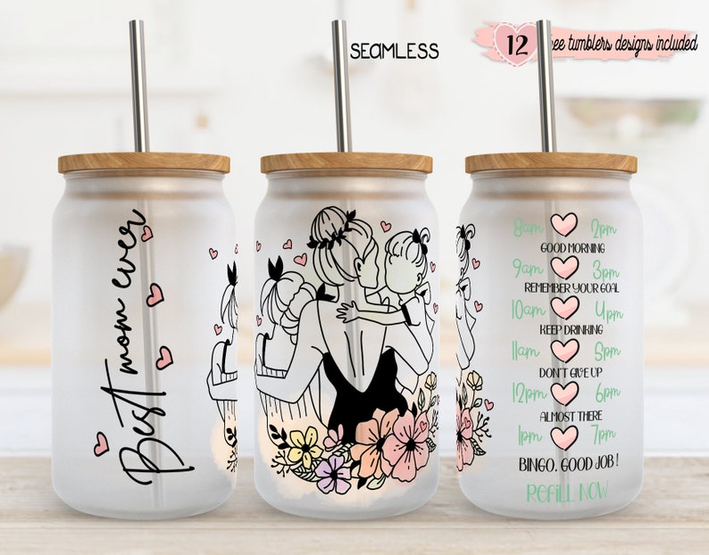 May include: Three frosted glass tumblers with bamboo lids and stainless steel straws. One tumbler reads "Best mom ever" with hearts. Another features a mother and children illustration. The third has a hydration schedule. "12 free tumblers designs included" is written on the top right.