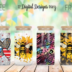 May include: Four glass tumblers with bamboo lids and straws. Designs include patriotic hearts, a bee on a sunflower, a zebra and leopard print, and a bee on a sunflower. The text reads "FREE 12 Digital Designs 16oz FREE".