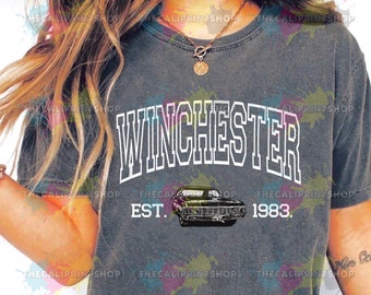 May include: A gray t-shirt with the text "Winchester Est. 1983." in white. A black car is pictured below the text.